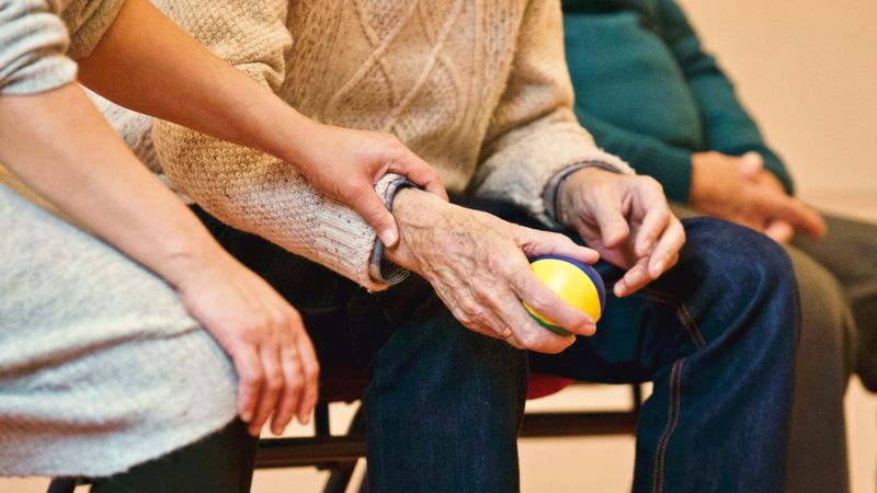 A caregiver gently assisting a senior